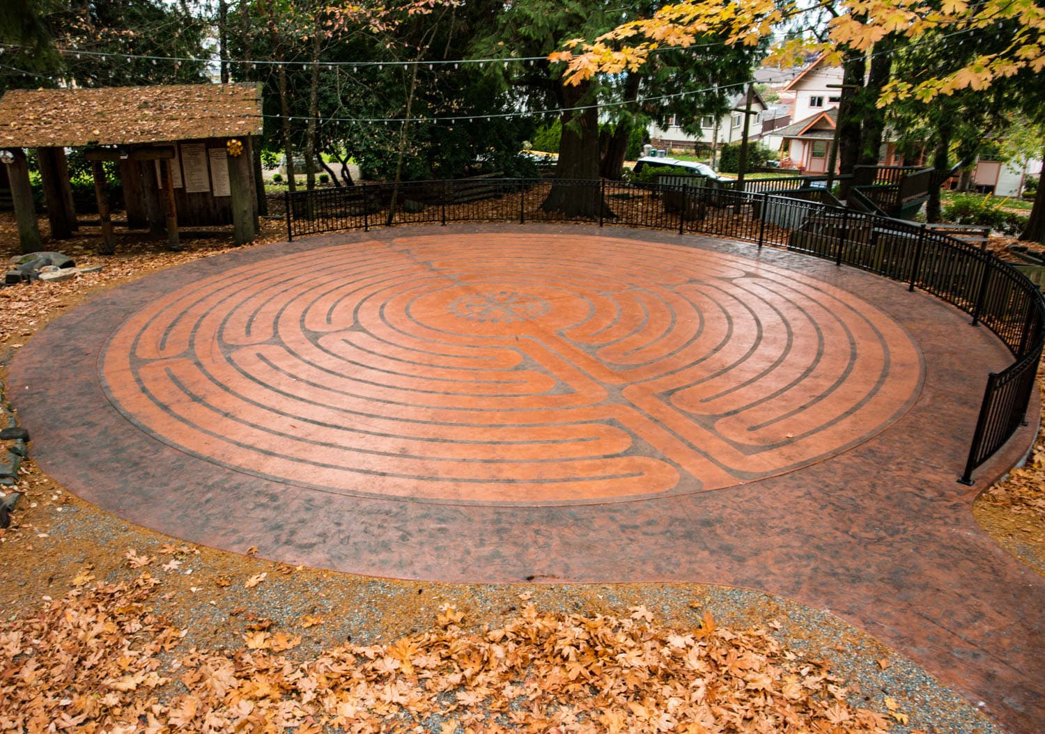 Circular labyrinth surrounded by autumn leaves