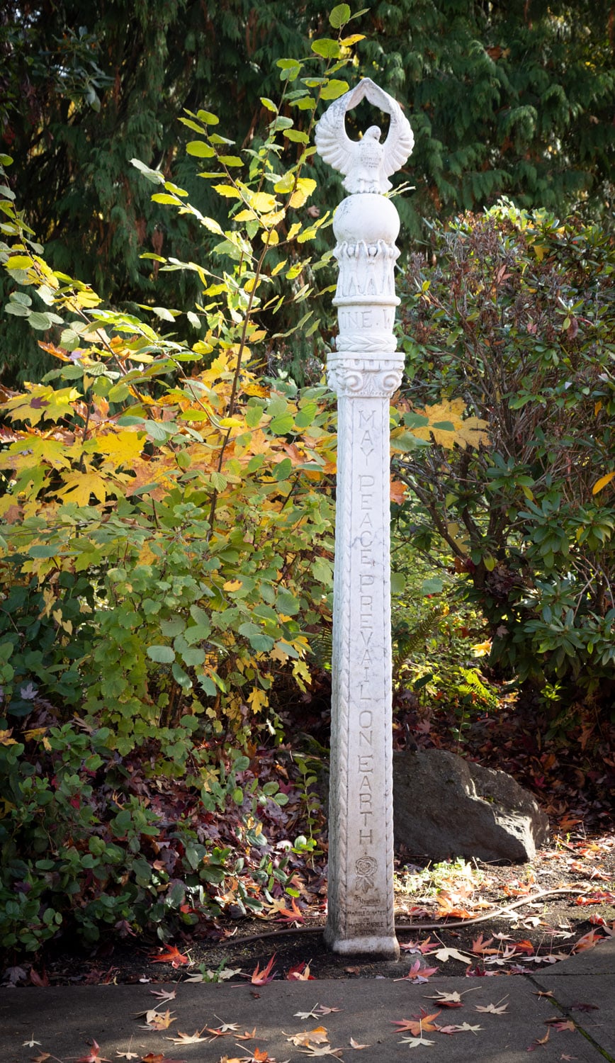 Tall peace pole surrounded by foliage