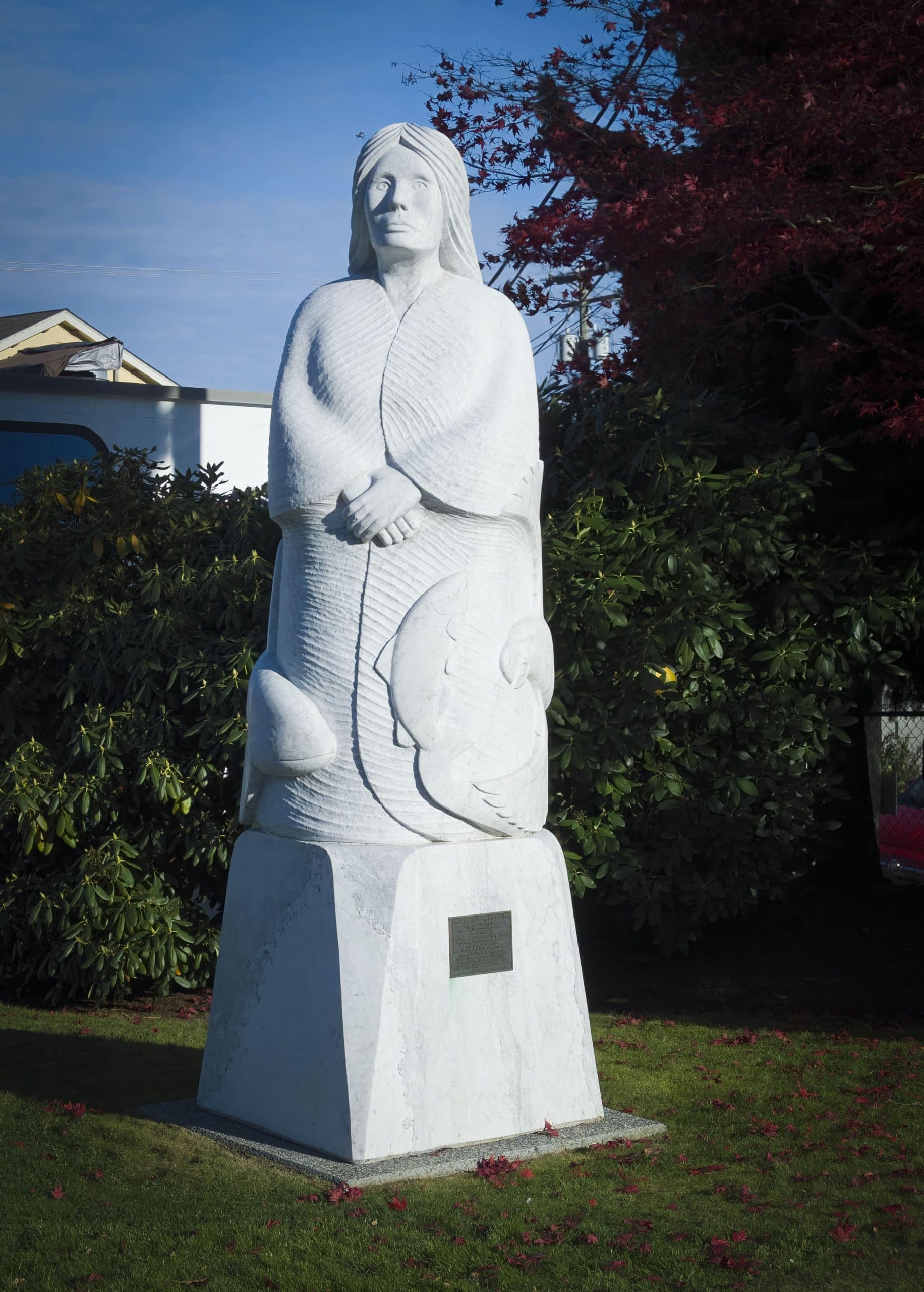White statue surrounded by greenery.