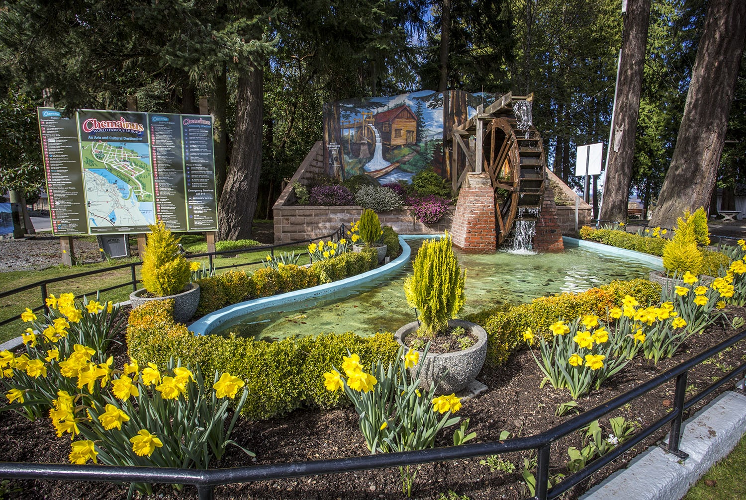 Waterwheel surrounded by flowers and greenery