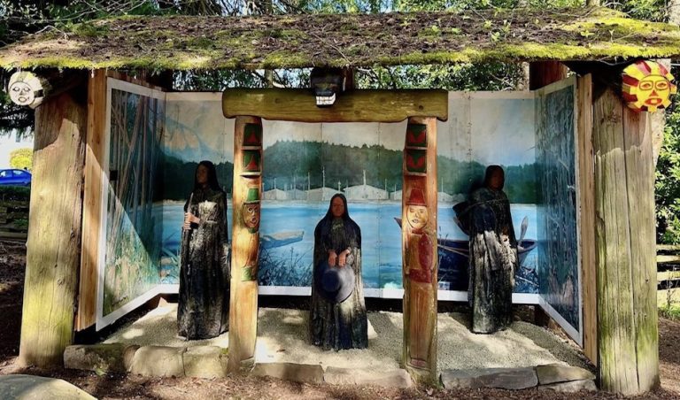 Wooden figures near painted backdrop.